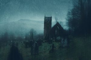 A spooky concept of a ruined church and graveyard in the countryside on a moody, foggy winters evening. With a grunge, abstract edit.