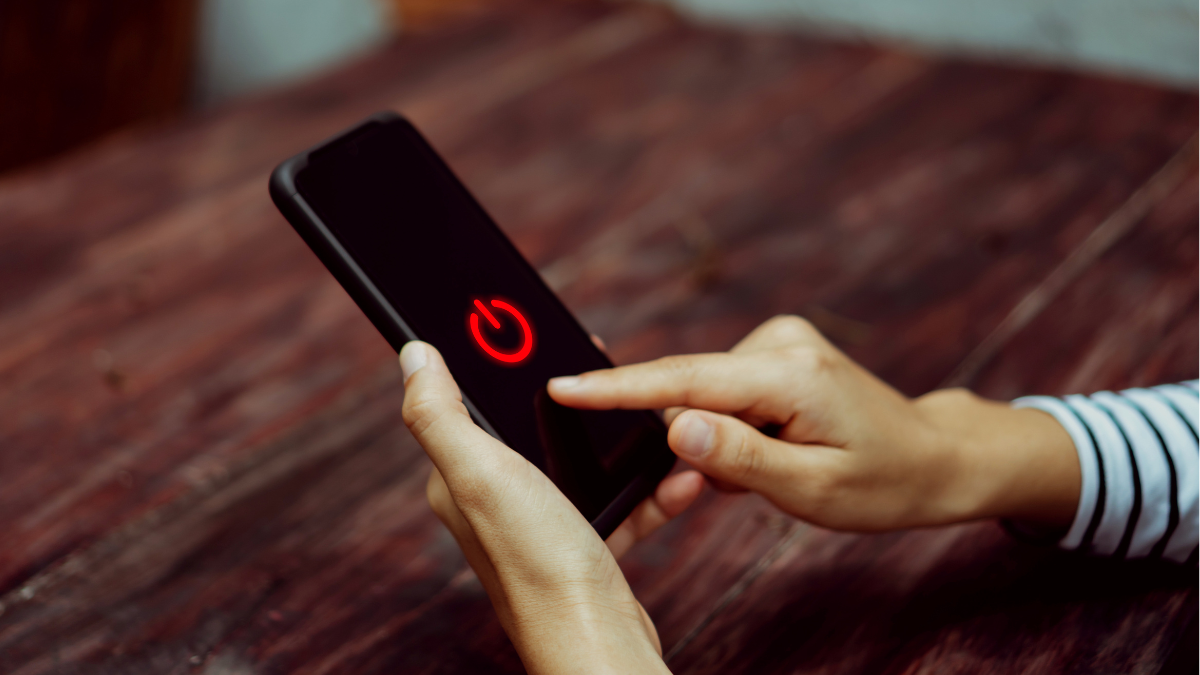 Persona apagando un celular (Foto vía Getty Images